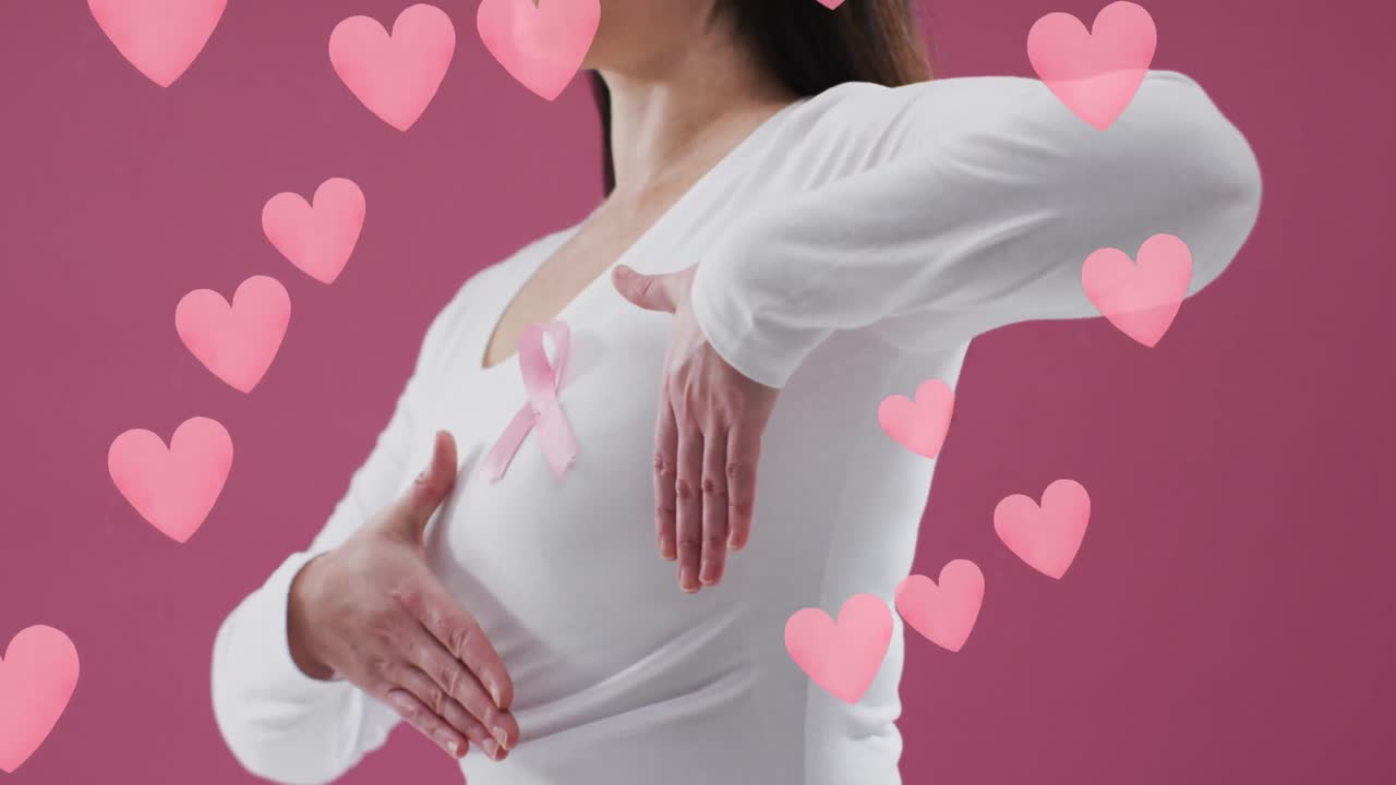 Animazione di cuori su donna caucasica con nastro rosa su sfondo rosa