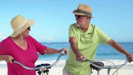 animación de hacerlo por ellos más feliz caucásica pareja de ancianos con bicicletas en la playa