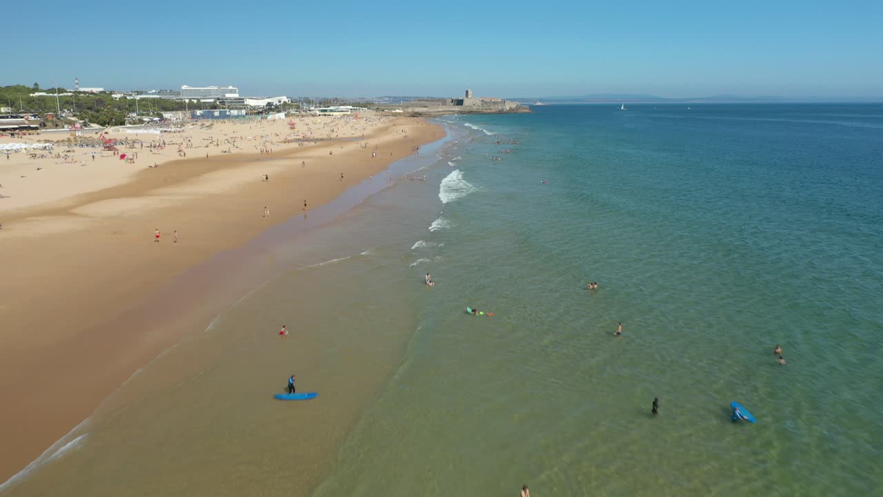 Aerial Drone Shot of people enjoying the beach and the water in Carcavelos, Lisbon, Portugal