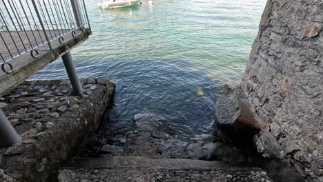 stone stairs descend into the clear lake water