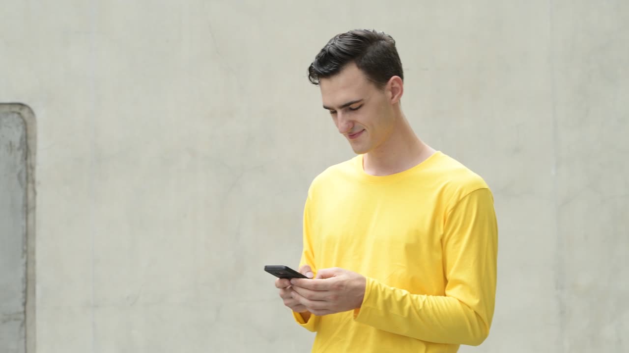 전화를 사용하는 행복한 젊은 잘생긴 남자