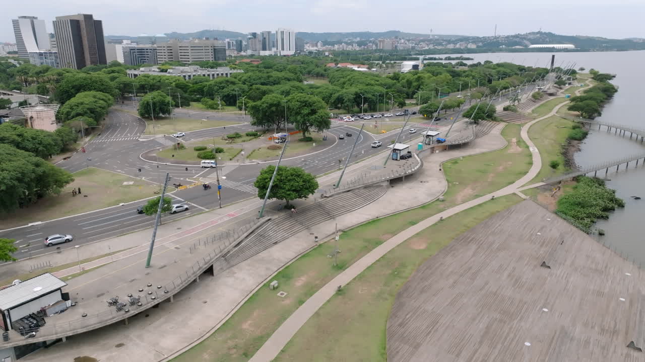 Vista aerea del traffico di Avenida Beira Rio e del lungomare di Porto Alegre. Include infrastrutture di parchi urbani e paesaggio urbano sotto un cielo nuvoloso. Registrato in video professionale 4K D-Log a 10 bit