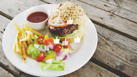 burger with fries and salad on plate, animation of thumbs-up icons over food