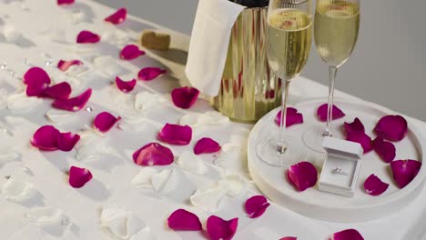 table set for romantic marriage proposal with champagne and engagement ring 2