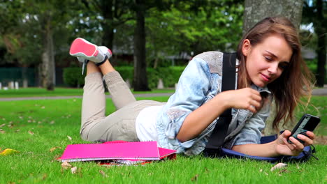 tired student lying on the grass and answering her phone