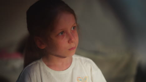 niño llorando abusa de la víctima en una habitación semi-oscura de primer plano. niña con ojos de agua de ofensa en un fondo borroso. niño asustado sufriendo de violencia