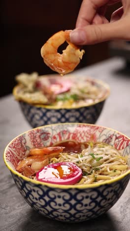 person eating shrimp ramen