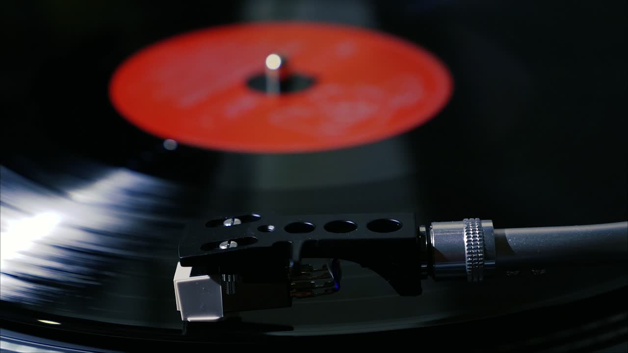 A black vintage vinyl record spins on a turntable with needle