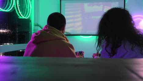 couple gaming in neon lit room