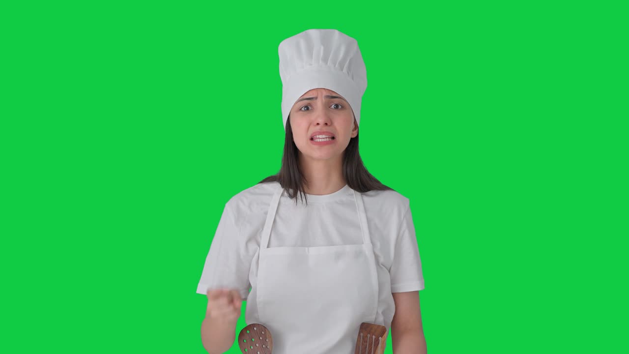 Chef professionista indiana arrabbiata che urla contro qualcuno. Schermo verde.