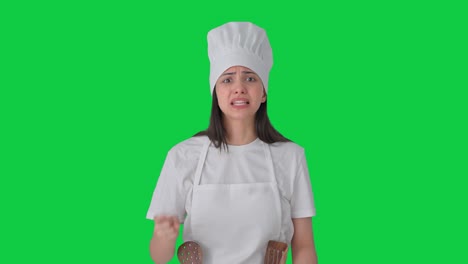 una mujer india enojada, una chef profesional, gritando a alguien en la pantalla verde.