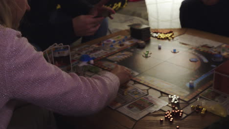 Female-checking-cards-in-hands-and-playing-board-game,-detail-view