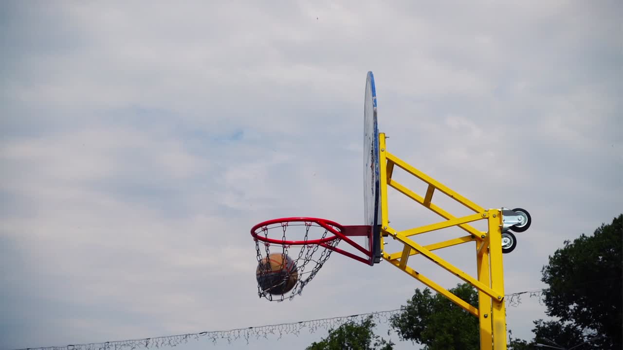 Pallacanestro da strada. La palla vola verso il canestro. Al rallentatore