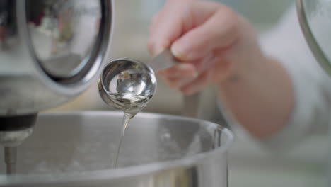 measuring olive oil with a measuring spoon