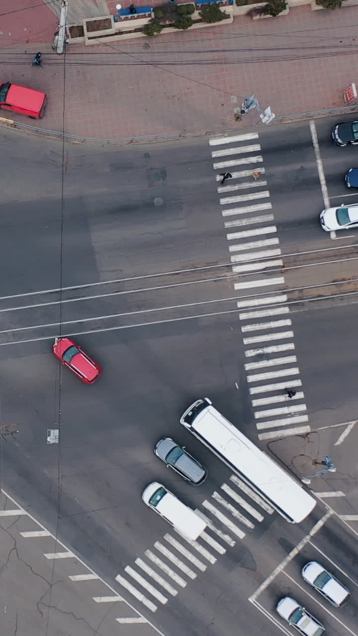 Aero shooting from above at the crossroads. City traffic. Traffic jams during rush hour in the city. White road markings. Vertical video