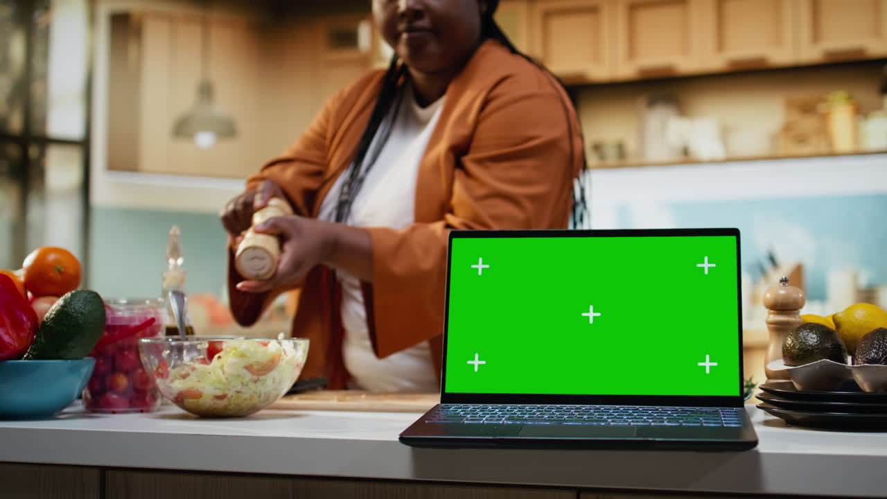 Chroma key terisolasi di laptop di samping influencer makanan yang sedang merekam vlog.