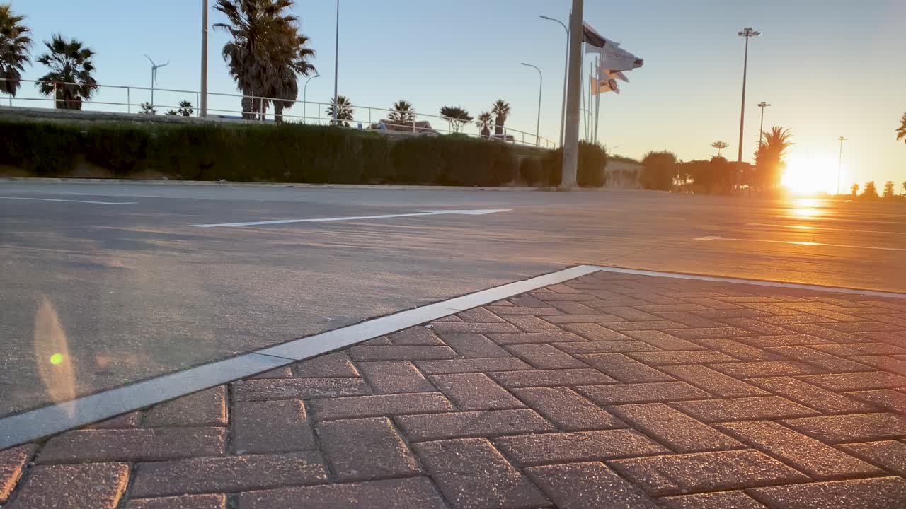 hombre emocionado tallando una carretera asfaltada en el parque de la playa el día de verano