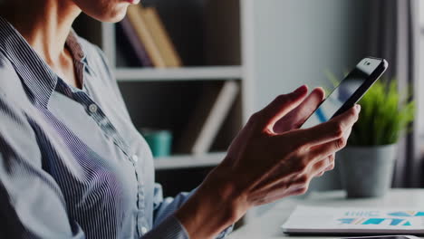 mujer usando teléfono inteligente en el escritorio
