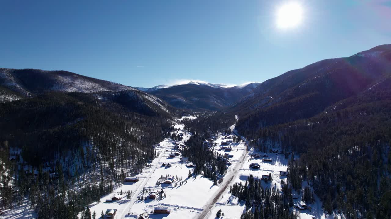 toma aérea de drones de casas ubicadas entre dos montañas en un día soleado