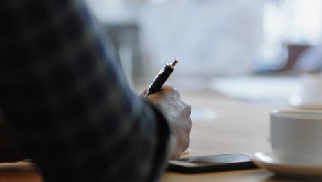 close-up-hand-businessman-writing-notes-using-pen-in-boardroom-meeting-brainstorming-creative-ideas-for-corporate-development-strategy-in-office-4k