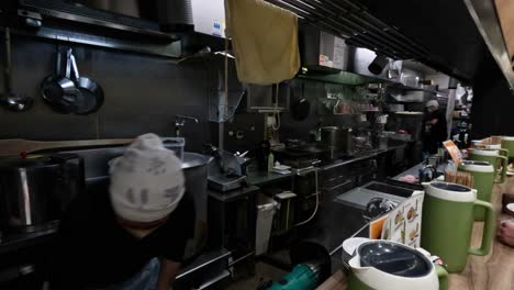 chef cooking ramen in a busy kitchen