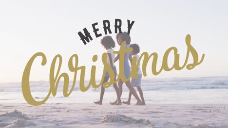 Animation-of-christmas-greetings-text-over-biracial-woman-with-son-and-daughter-on-beach