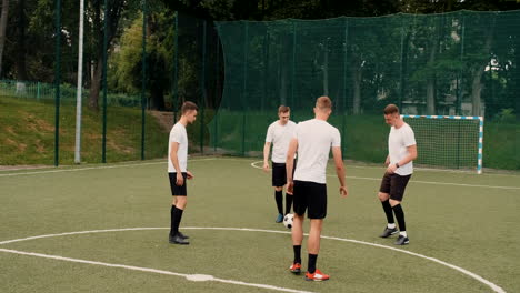 group of young soccer players training and passing ball to each other on a street football pitch on a sunny day 4