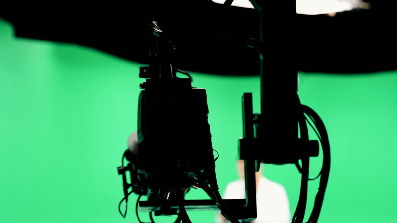 equipo de filmación en el estudio verde de rodaje de video. croma - tecnología de combinar dos o más imágenes o cuadros en una sola composición. camarógrafo, director, equipo. industria cinematográfica.