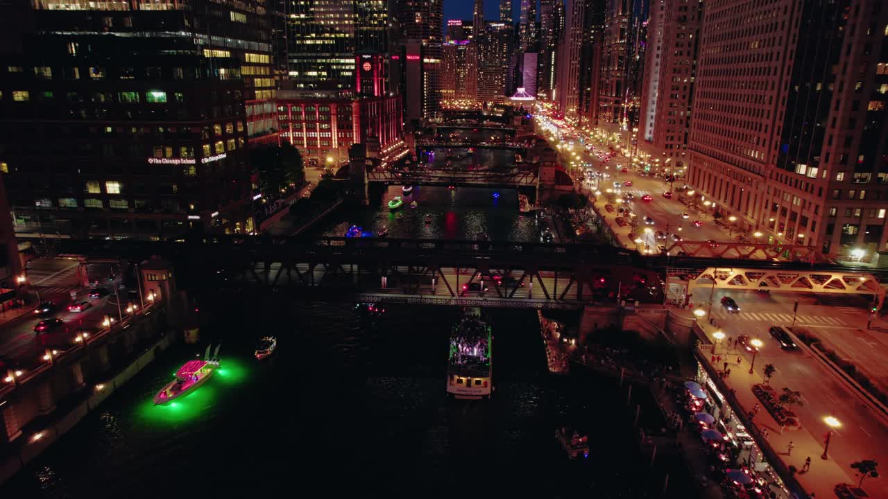 Chicago’s lit river canyon as party boats move beneath glowing bridges. Downtown full of nightlife activities