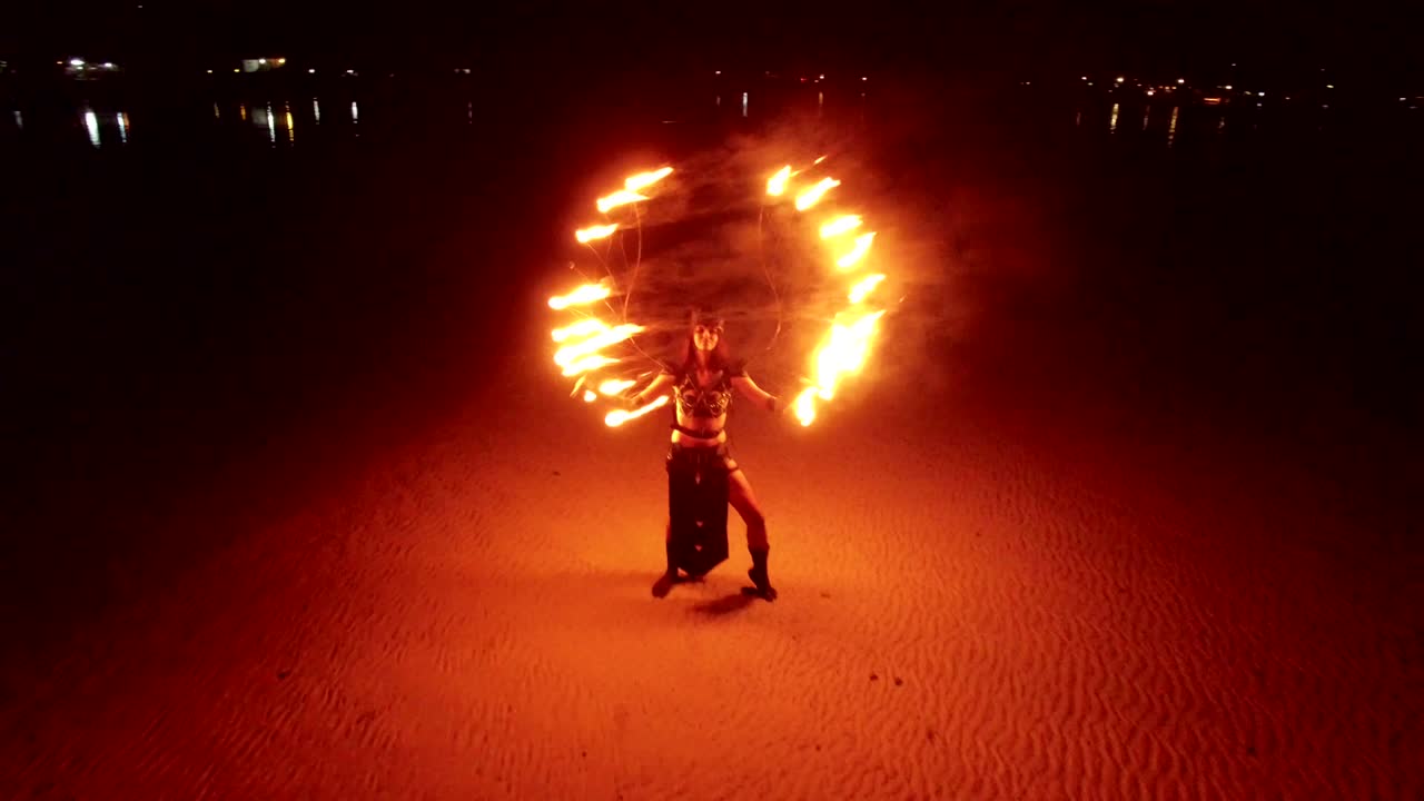 espectáculo de fuego de baile en la playa de bancos de arena al atardecer