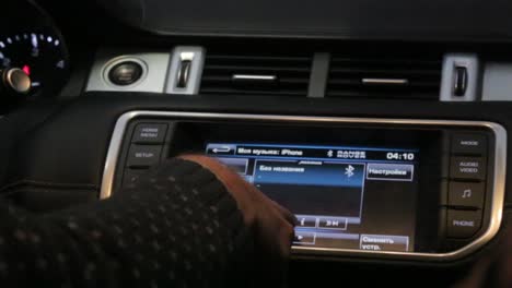 persona que ajusta el sistema de infoentretenimiento del automóvil