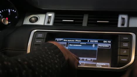 person adjusting car infotainment system