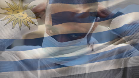 animación de la bandera de uruguay ondeando sobre un hombre que usa una máscara facial durante la pandemia de covid 19
