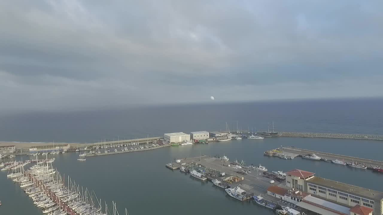 Isolated white balloon flying away over Arenys de Mar. Aerial circling