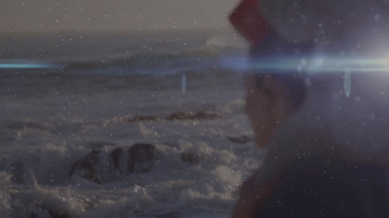 Wearing red hat, child gazing at ocean with lens flare effect animation