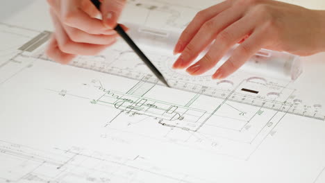 close-up of hands working on architectural blueprints