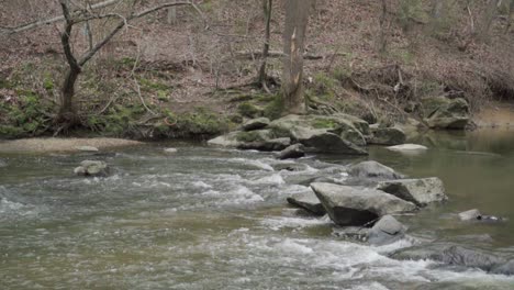 stream of water flowing over rocks in slow motion with small waves during fall