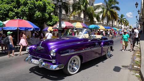 coche descapotable púrpura en un mercado cubano