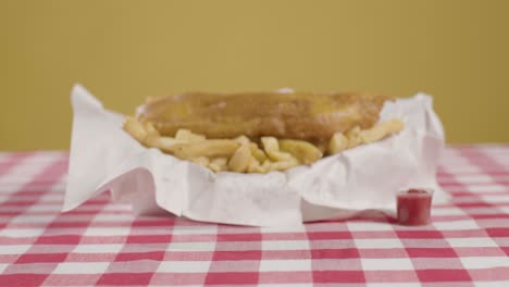 persona que come una comida tradicional británica de pescado y papas fritas