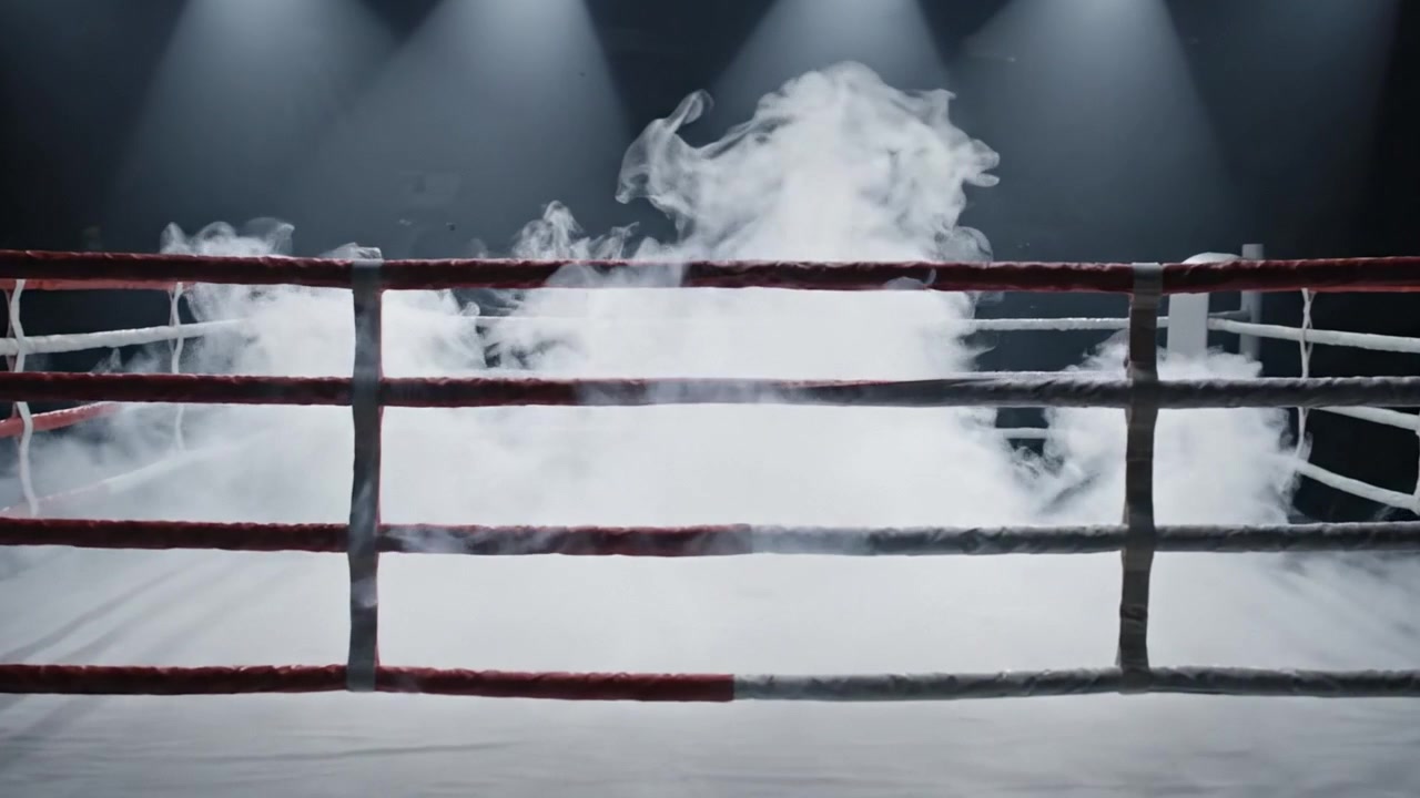 Una transizione drammatica di scena di un ring di pugilato: da un'arena chiara a un ambiente misterioso e pieno di fumo, catturata in due scatti mozzafiato.