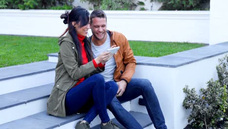 pareja divirtiéndose mientras usan un teléfono móvil 4k