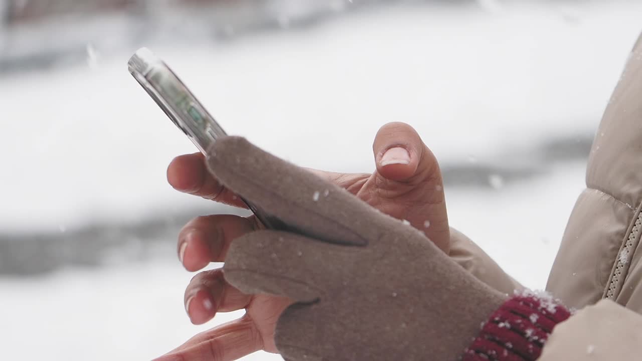 눈 속에서 스마트폰을 사용하는 사람