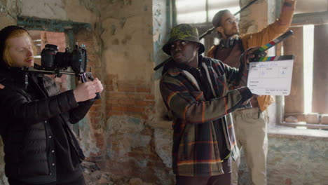 production team and cameraman recording a scene in a ruined building