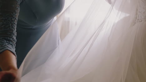 mother-adjusts-lacy-veil-of-young-daughter-in-wedding-dress