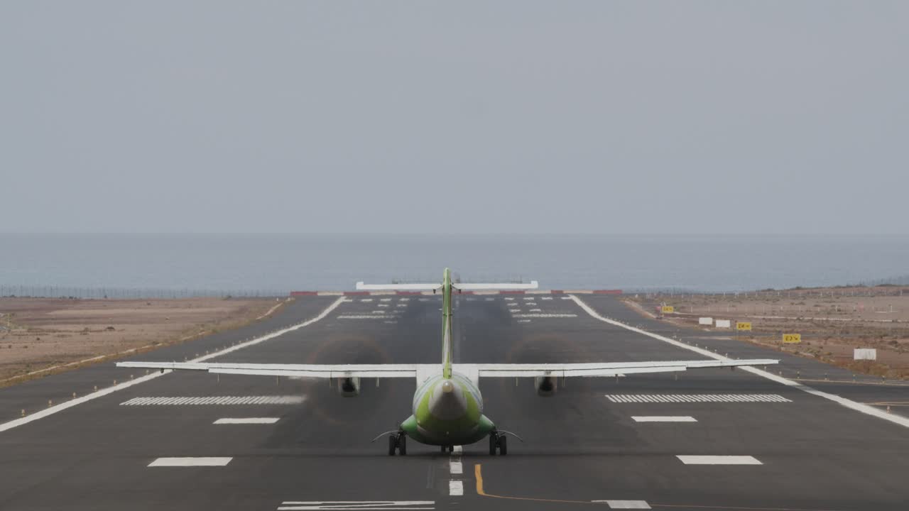 Aircraft taking off from runway by the ocean
