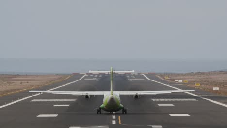 aircraft taking off from runway by the ocean