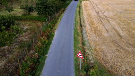 Car-Crossing-Rural-Road-In-Piedmont,-Close-to-Castagnole-Delle-Lanze-Small-Town,-Italy