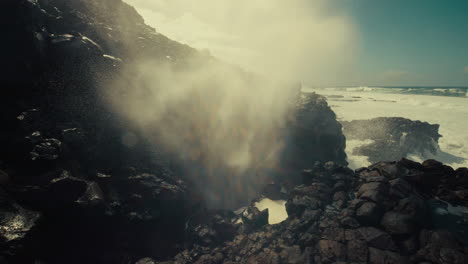 powerful ocean waves crashing against volcanic rocks
