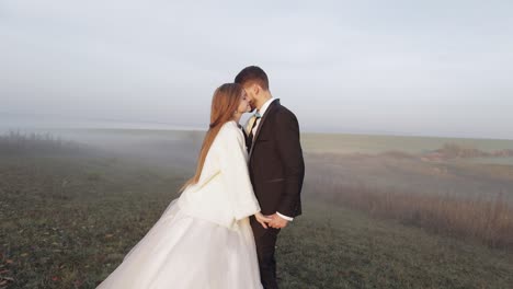 Newlyweds.-Caucasian-groom-with-bride-on-the-morning-field.-Fog.-Wedding-couple