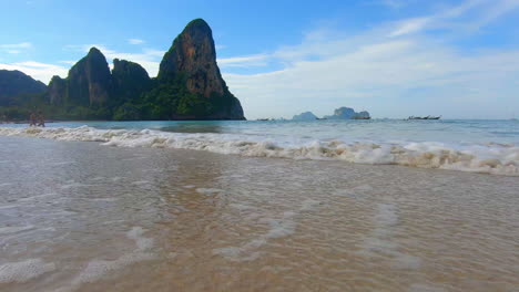 slow motion | waves crashing on a beach in thailand with islands off in the distance